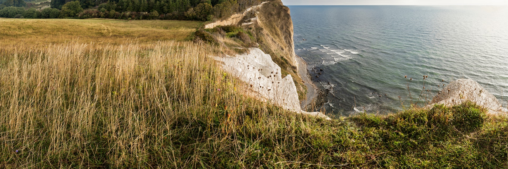 Panoramic shot made up of 4 vertical frames stitched together of the  landscape view of the famous chalk cliffs at Møns Klint on the island of Møn, Denmark. The cliffs run for 8 km along the coast ranging in height from a few meters above sea level to over 120m. The area is a popular destination for holiday makers looking for some adventure with lots of hiking trails, mountain bike tracks, sea kayaking and sport fishing activites all catered for. The tall slim tower almost hidden in the trees is a relic of the Cold War, it was an early warning radar station, that due to it's location in the Baltic  could "see" into Russian airspace, now it is used to monitor shipping.