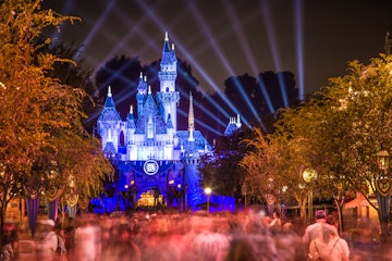 Anaheim, CA USA - September 3, 2015: Disneyland 60th celebration castle with people This year Disneyland celebrates its 60th aniversary of been open. On this day the park celebrated with fireworks and over 150 thousand people. People are exiting the park after a long day of fun and celebrations.