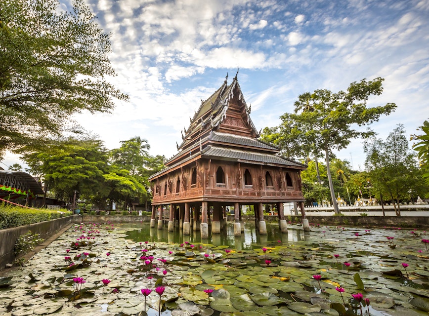 Thai wooden temple architecture on the lotus pond at wat Thung Si Muang in Ubon Ratchathani province, Thailand
