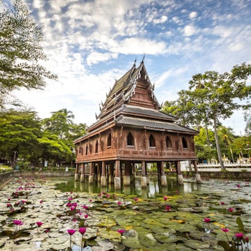 Thai wooden temple architecture on the lotus pond at wat Thung Si Muang in Ubon Ratchathani province, Thailand