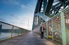 A tourist walking on the Hohenzollern Bridge and looking to the colorful love padlocks in Cologne (Koln), Germany ; Shutterstock ID 528287434; your: Tasmin Waby; gl: 65050; netsuite: Online Editorial; full: Demand Project