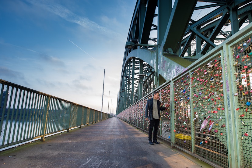 A tourist walking on the Hohenzollern Bridge and looking to the colorful love padlocks in Cologne (Koln), Germany ; Shutterstock ID 528287434; your: Tasmin Waby; gl: 65050; netsuite: Online Editorial; full: Demand Project