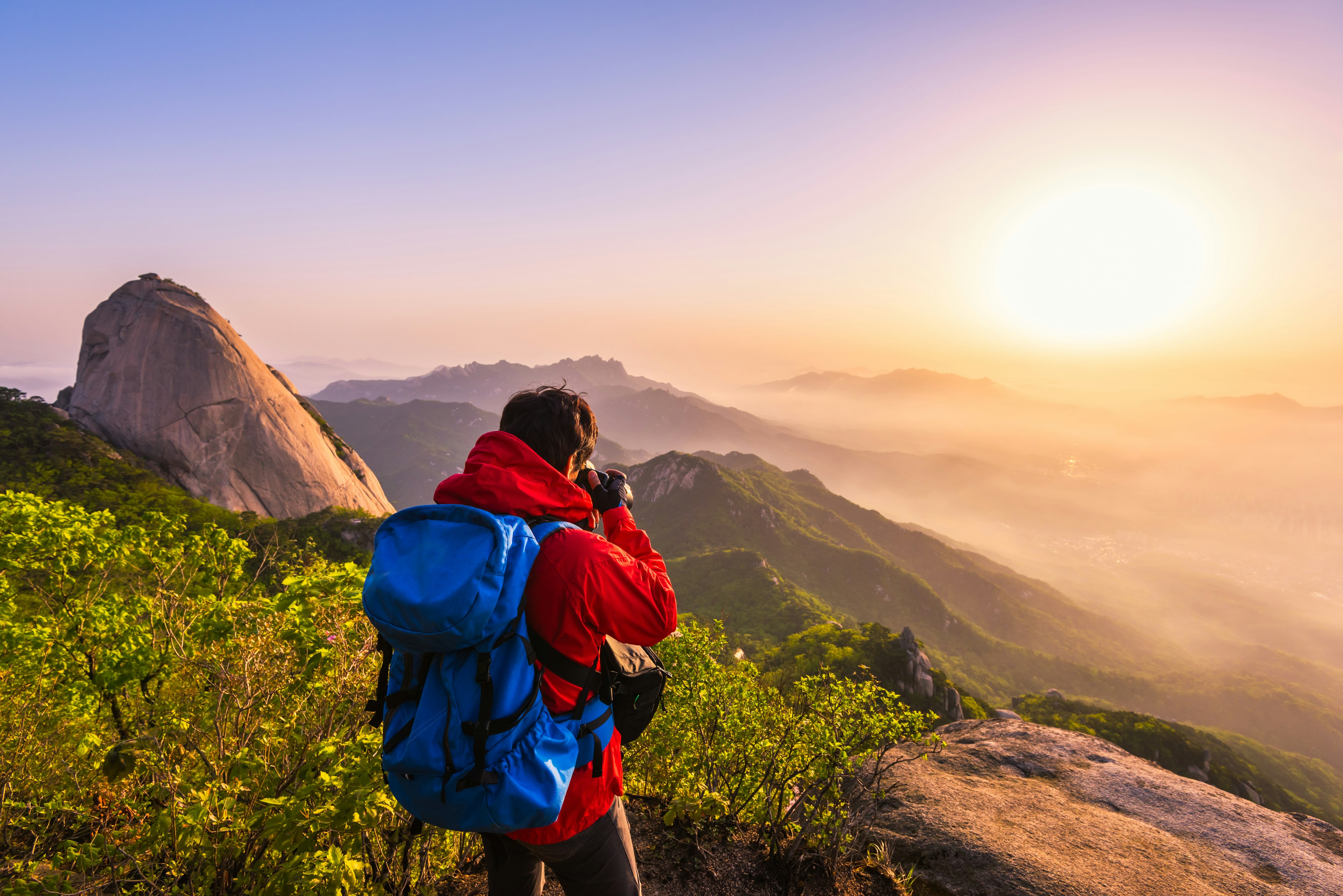 A photographer takes photos of the sunrise from Bukhansan mountain