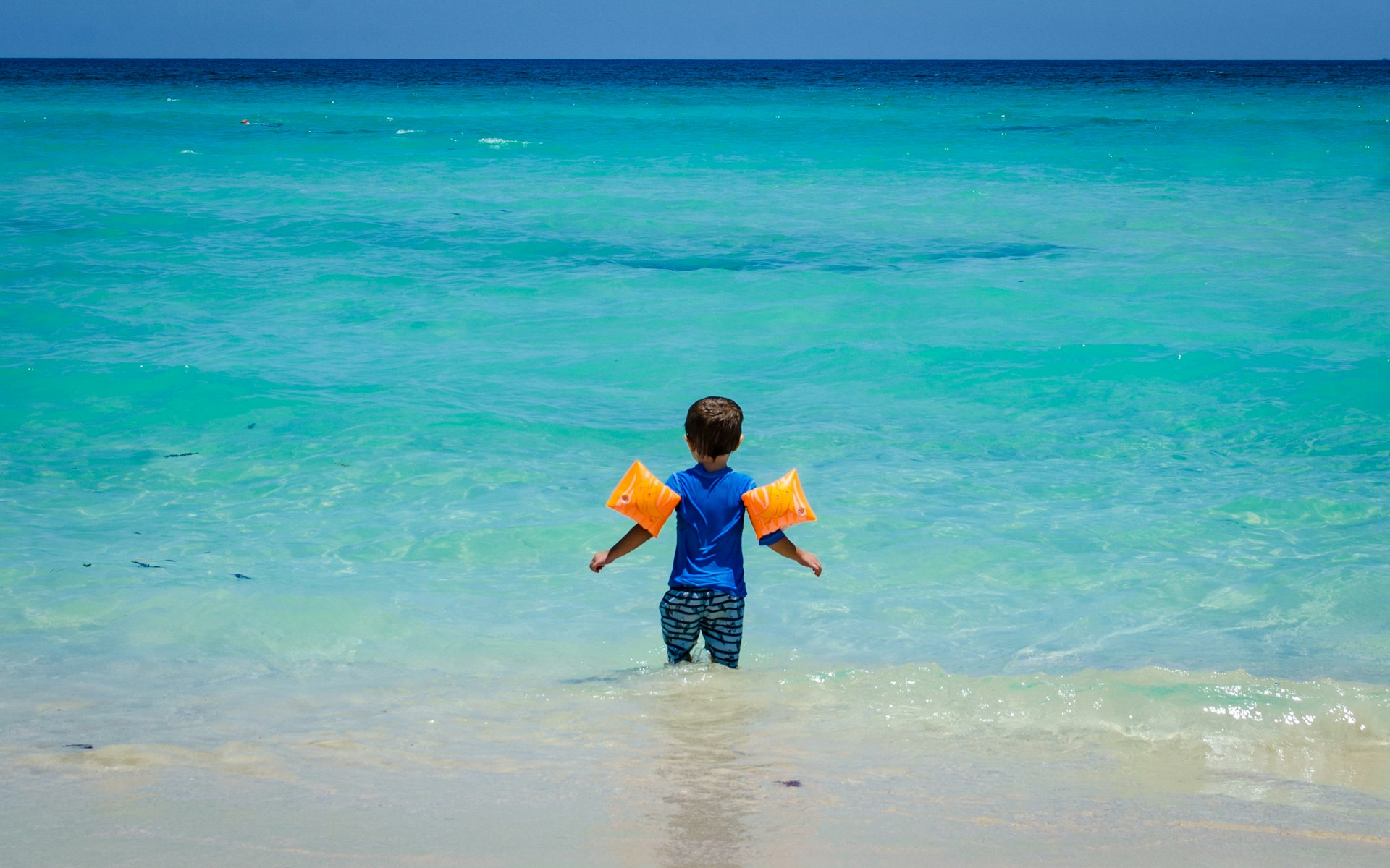 年幼的孩子在古巴海滩上穿着浮标