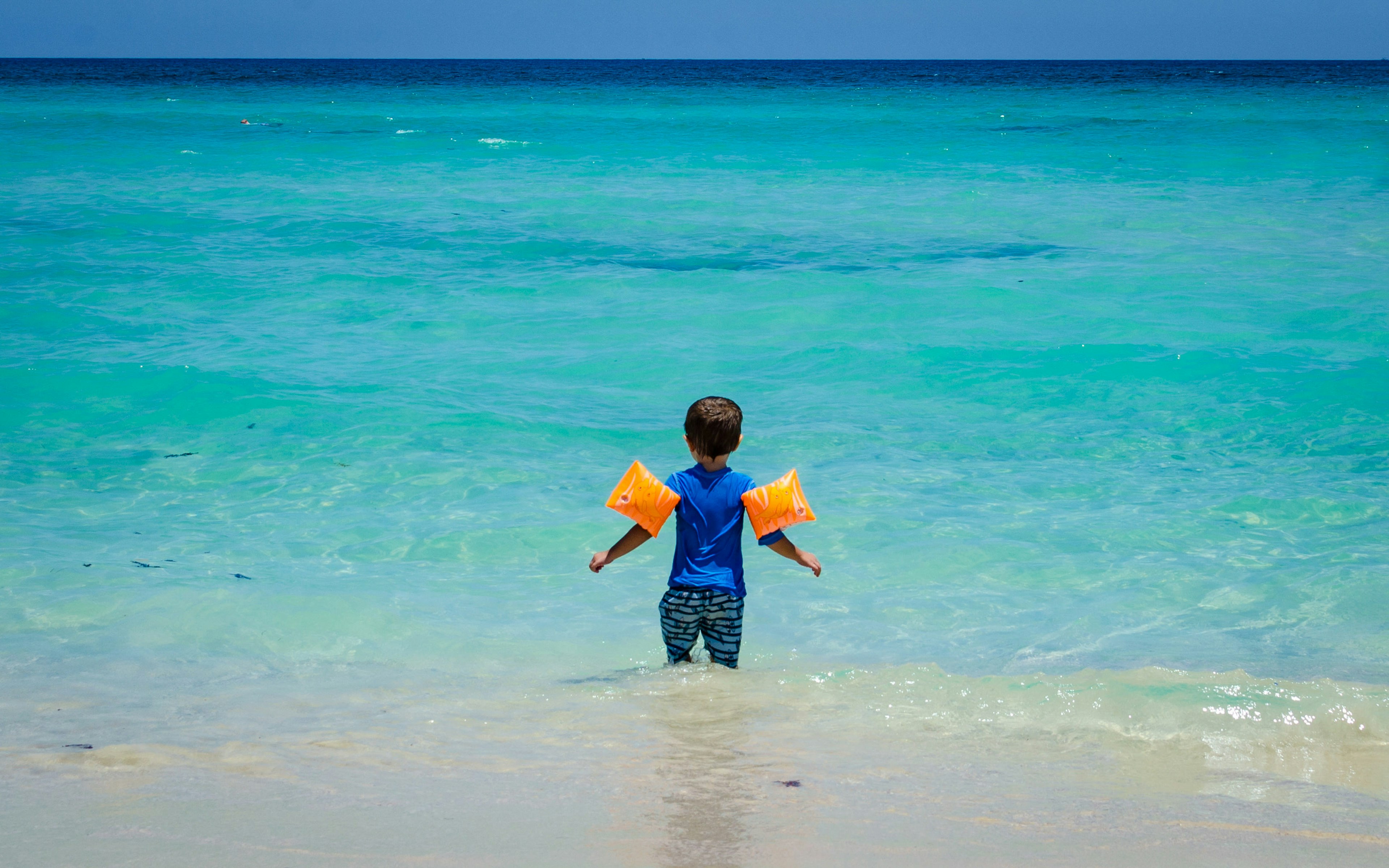 Young child wearing floaties at a Cuban beach