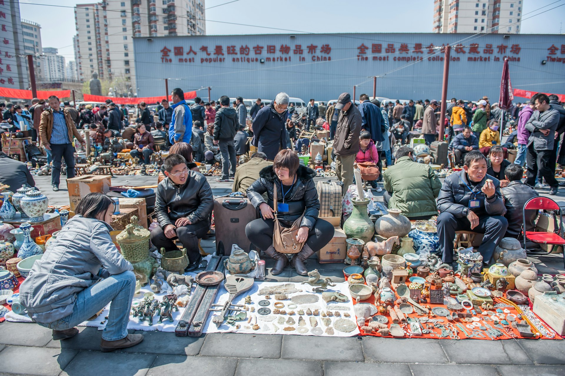 People gather in front of vendors at Panjiayuan market in Beijing