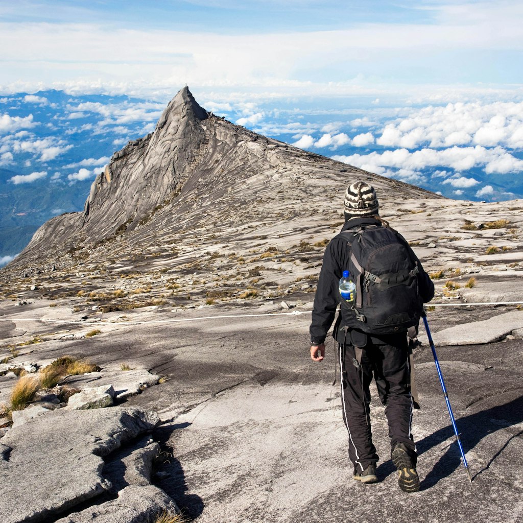Hiker at the top of Mount Kinabalu in Sabah, East Malaysia. The climb to the summit of Mount Kinabalu is one of Sabah's most popular tourist attractions.