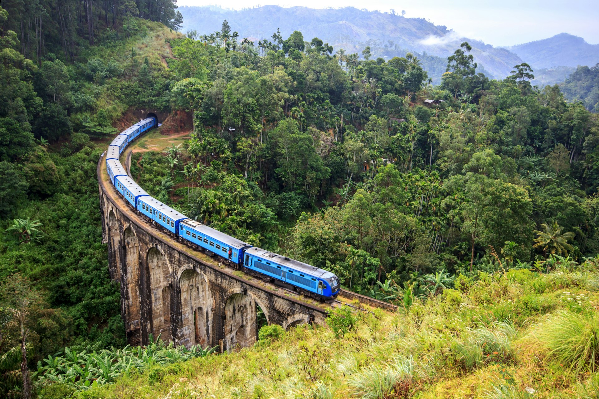 A blue train on the Nine Arch Bridge, Demodara, in Sri Lanka