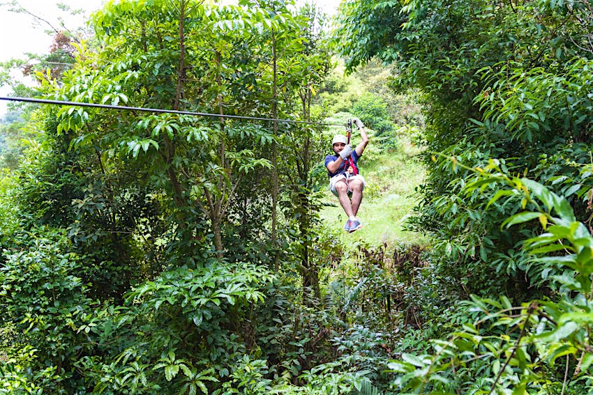 A young adventurous man zip-lining through the cloud forest of Monteverde