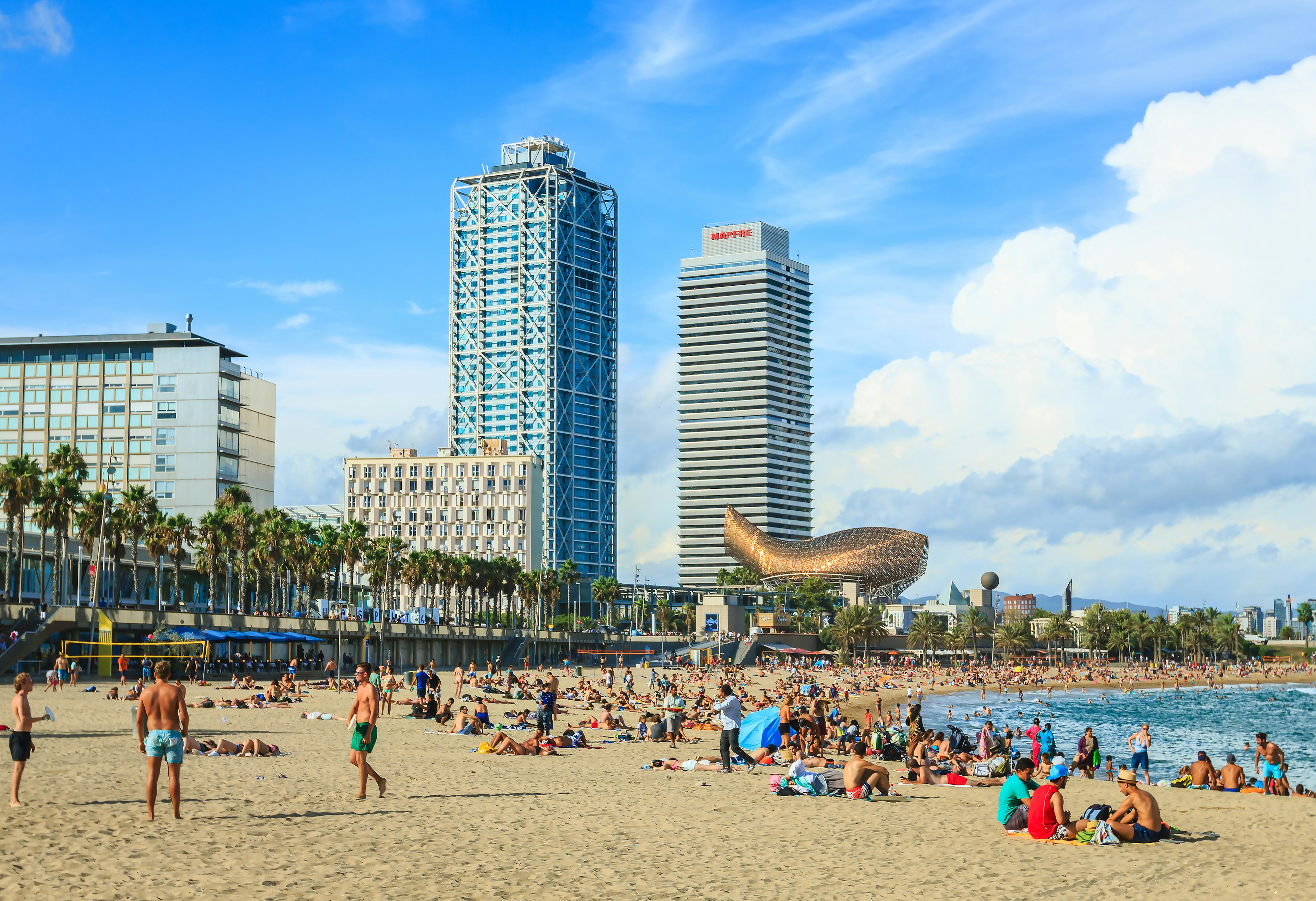 Many tourists and locals enjoying on famous beach in Barcelona, Spain