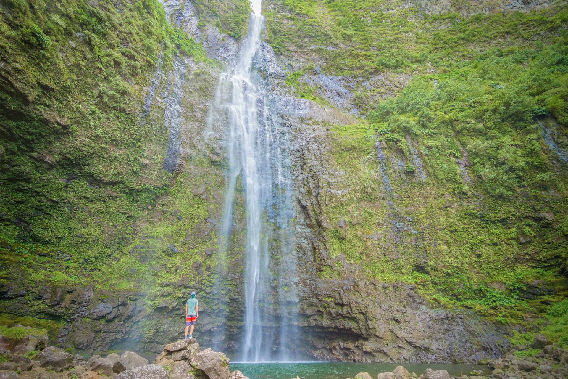 A man gazing up at Hanakapi'ai falls on ܲʻ island, Hawaii