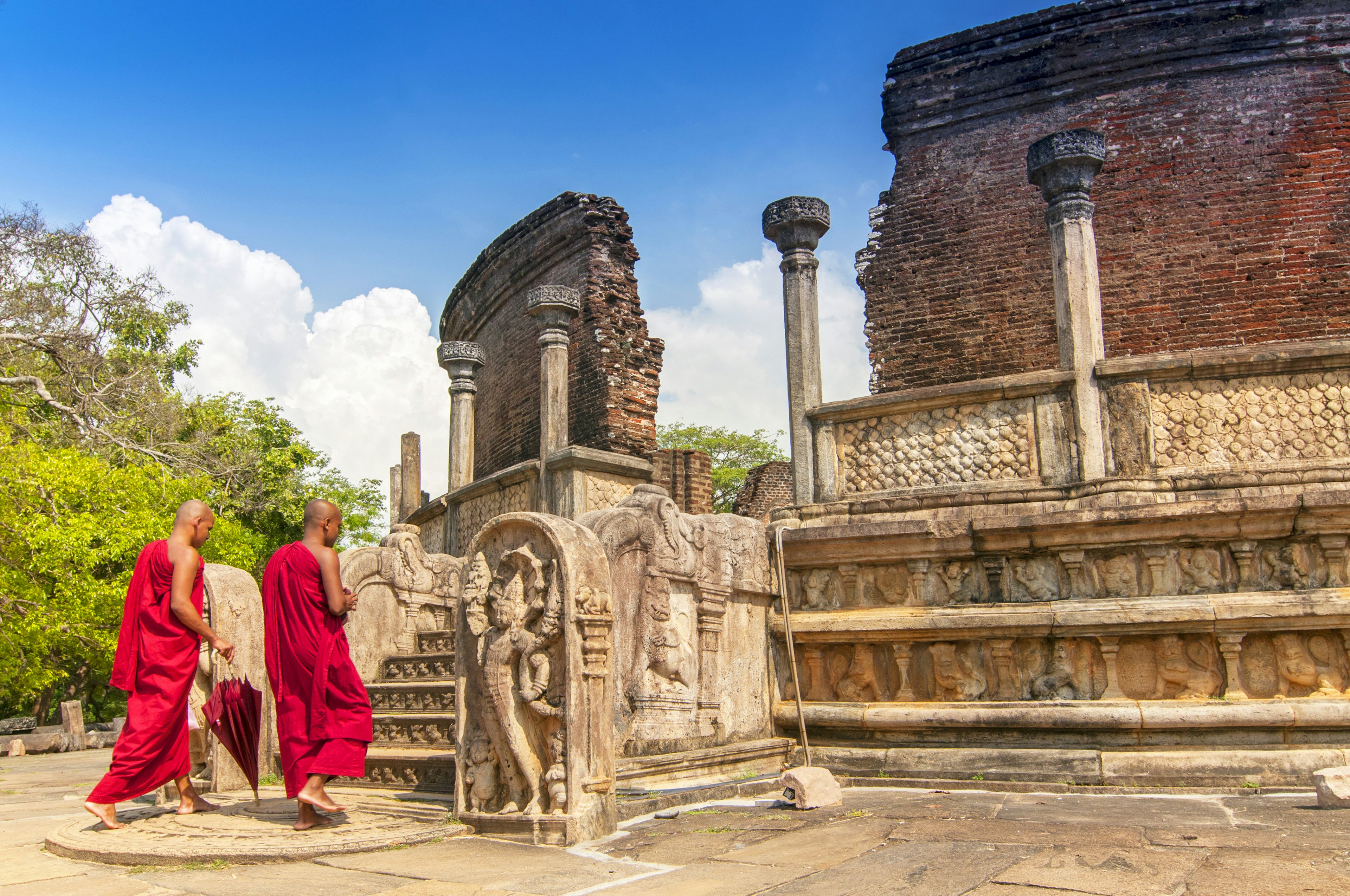 Two bare-foot monks enter the ruins of a temple building