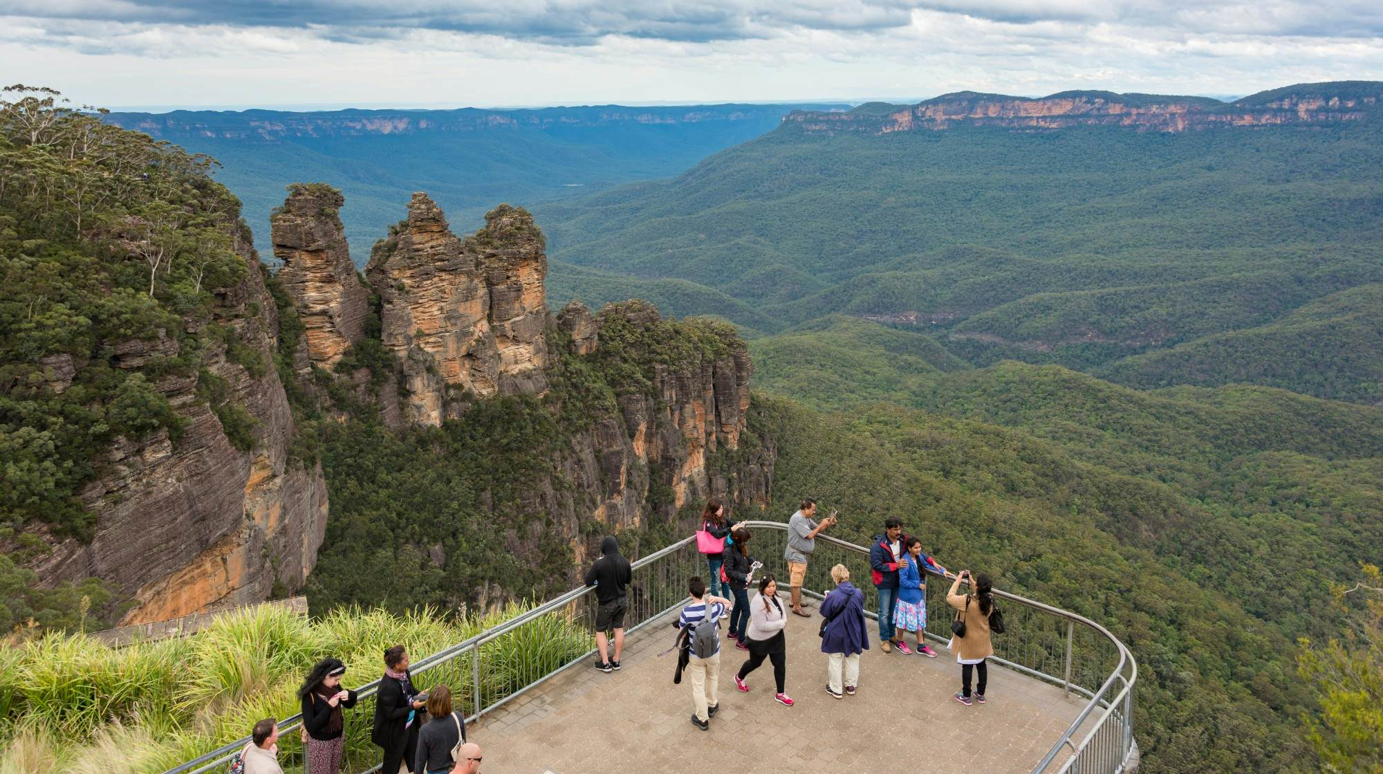 Blue Mountains, Australia - May 1, 2016: People at observation deck at Echo point lookout with view of famous Three Sisters mountains and Blue Mountains eucalyptus forest