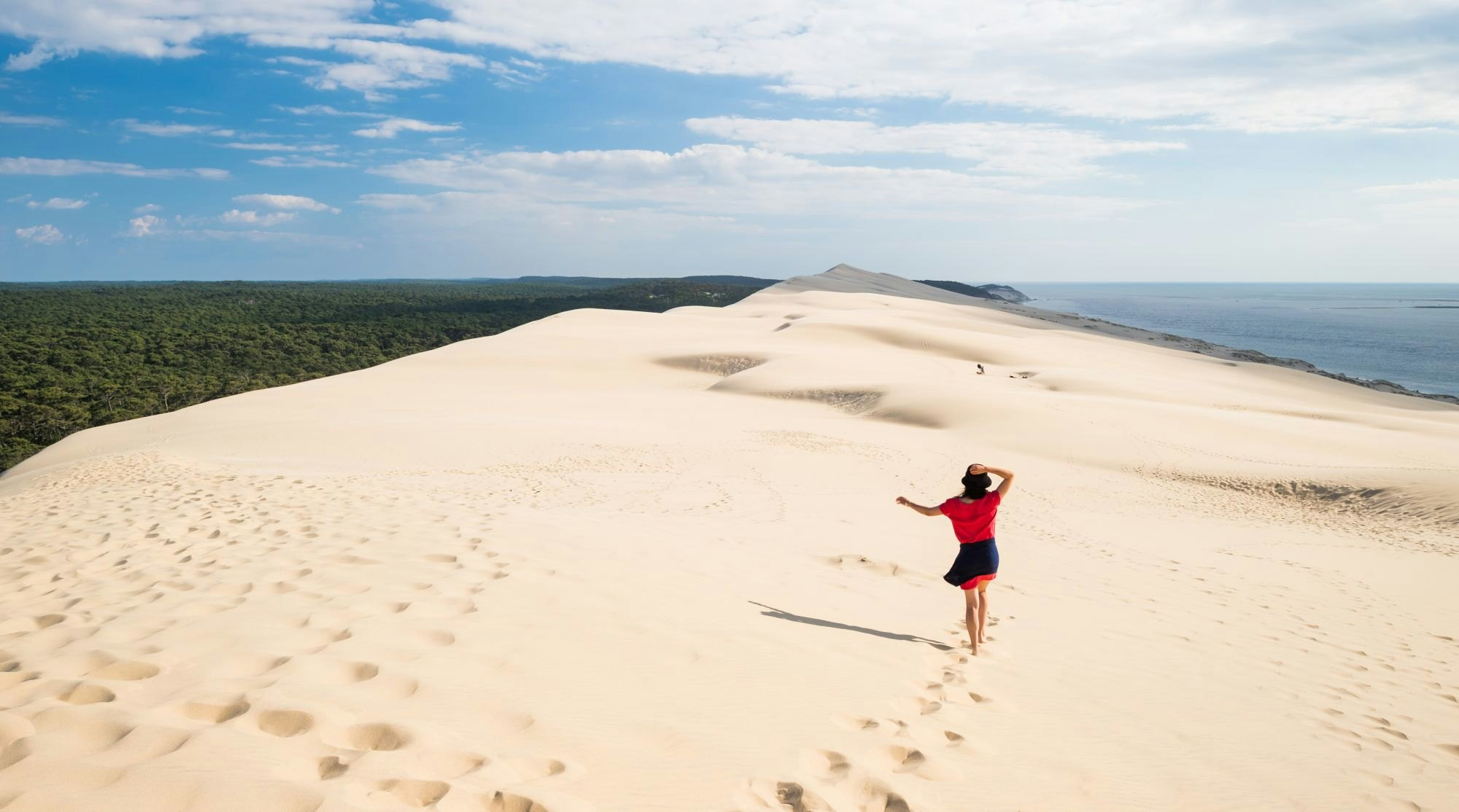 Woman walking on the dune in Dune du Pilat in southern France.