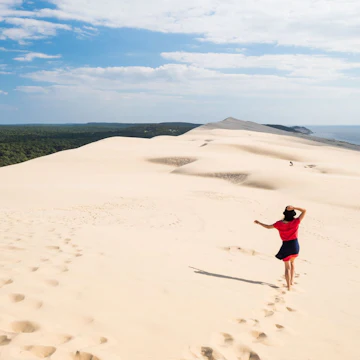 Woman walking on the dune in Dune du Pilat in southern France.