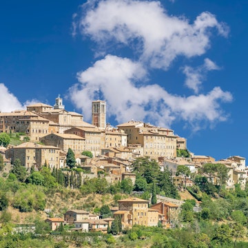 Stunning view of the Tuscan hilltop village of Montepulciano, Siena, Italy, on a sunny day with some white clouds