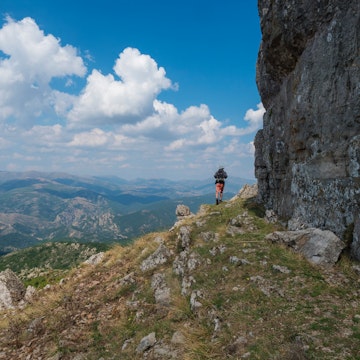 Lonely man hiker walking around limestone tower Perda Liana, impressive rock formation on green forest hill, sardinian table mountain. National Park of Barbagia, Central Sardinia, Italy, summer day; Shutterstock ID 1897245283; your: Erin Lenczycki; gl: 65050; netsuite: Online Editorial; full: Destination update