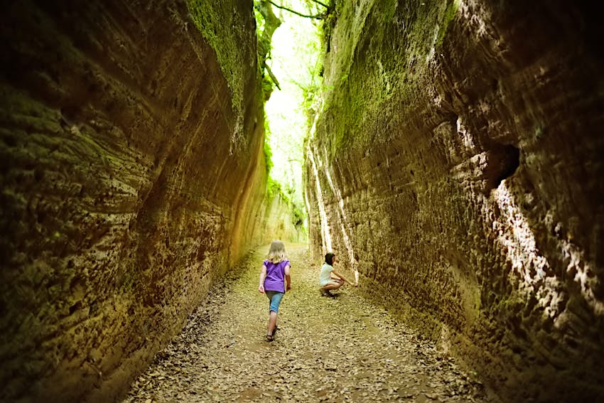 I bambini vagano per vie cave, scavo di antiche strade etrusche nella Necropoli di Sovana