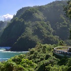 Curvy coastal road with views of cliffs, beaches, waterfalls.