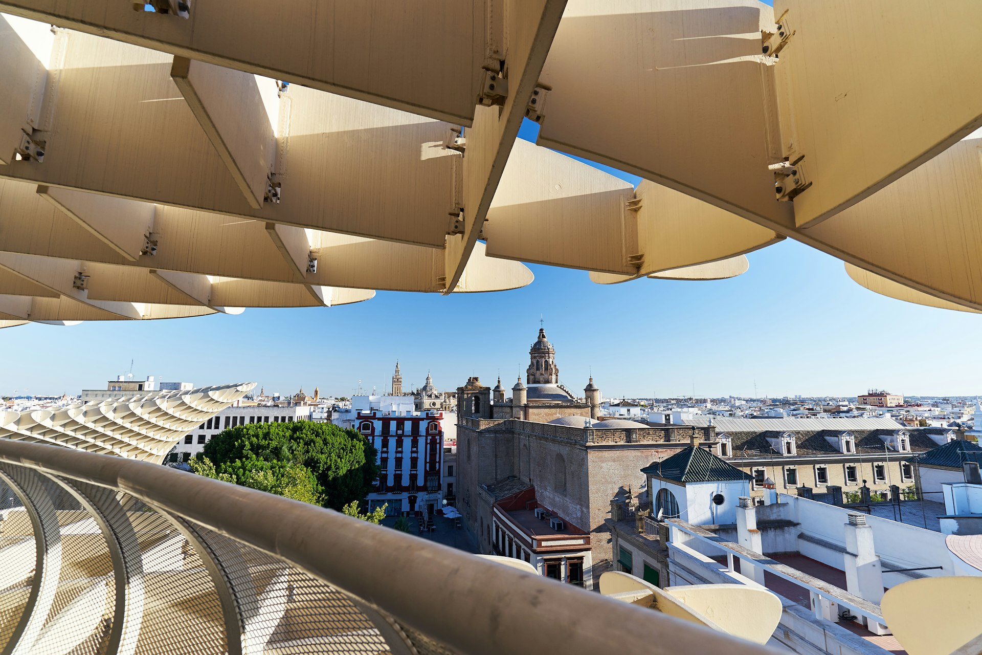 A wooden modern elevated walkway offering views over older city buildings