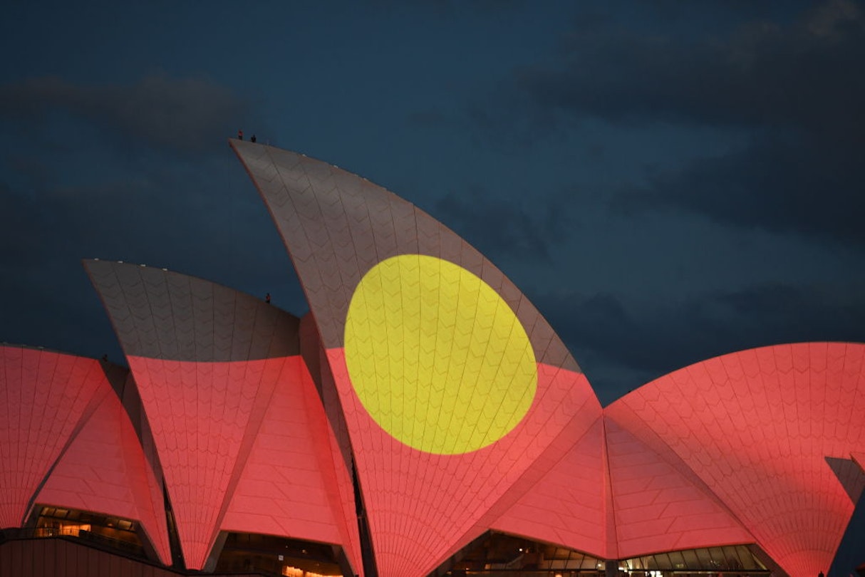 SYDNEY, AUSTRALIA - JANUARY 26: The Aboriginal flag is projected onto the sails of the Opera House during the Australia Day Live concert on January 26, 2022 in Sydney, Australia. Australia Day, formerly known as Foundation Day, is the official national day of Australia and is celebrated annually on January 26 to commemorate the arrival of the First Fleet to Sydney in 1788. Indigenous Australians refer to the day as 'Invasion Day' and there is growing support to change the date to one which can be celebrated by all Australians. (Photo by James D. Morgan/Getty Images)