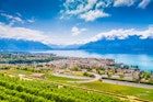Aerial panoramic view of the city of Vevey at Lake Geneva with vineyards of famous Lavaux wine region on a beautiful sunny day in summer, Switzerland.