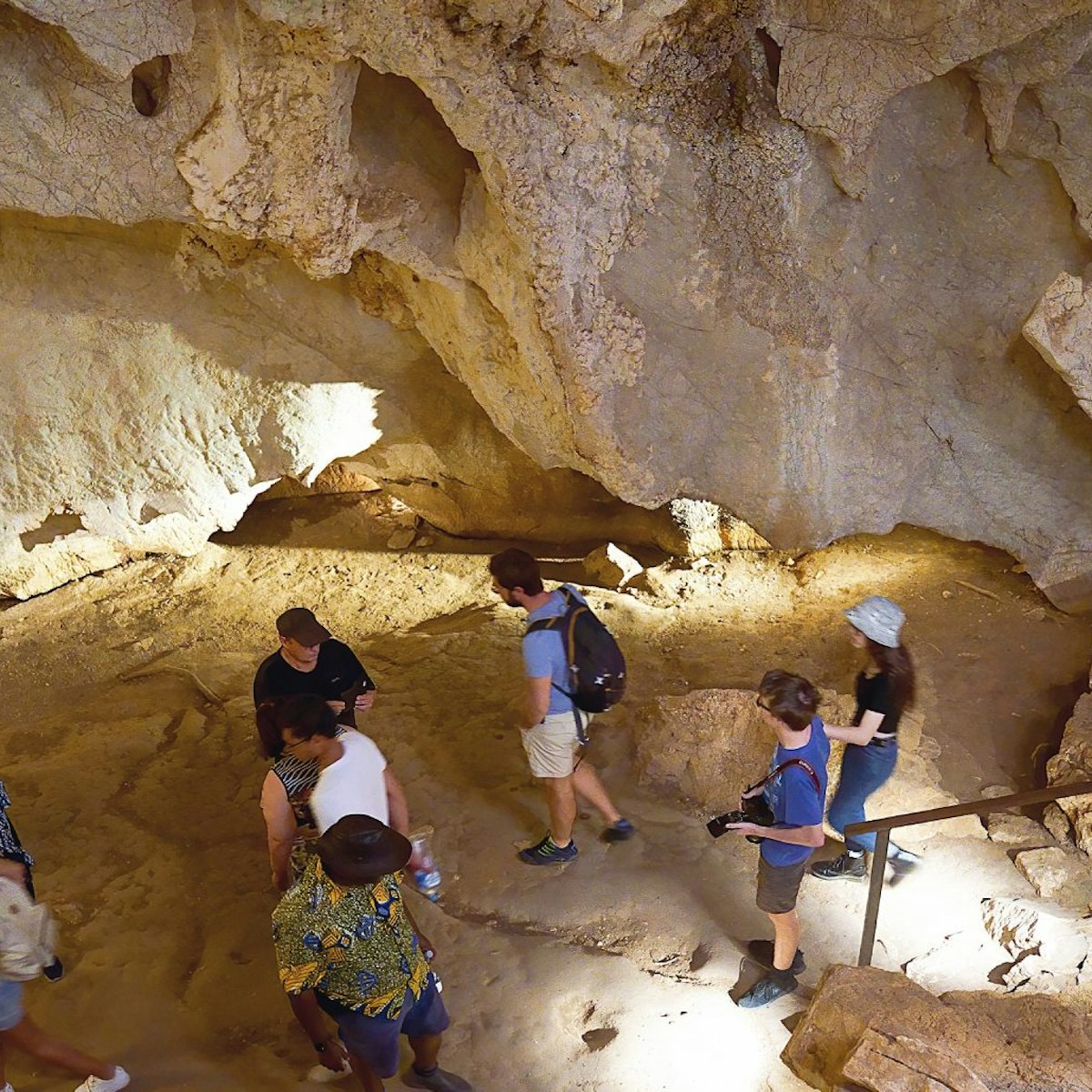 Queensland, Australia - December 2019: Tourists inside a cavern explore the ecosystem of the Capricorn Caves. Photography difficult due to very low light.