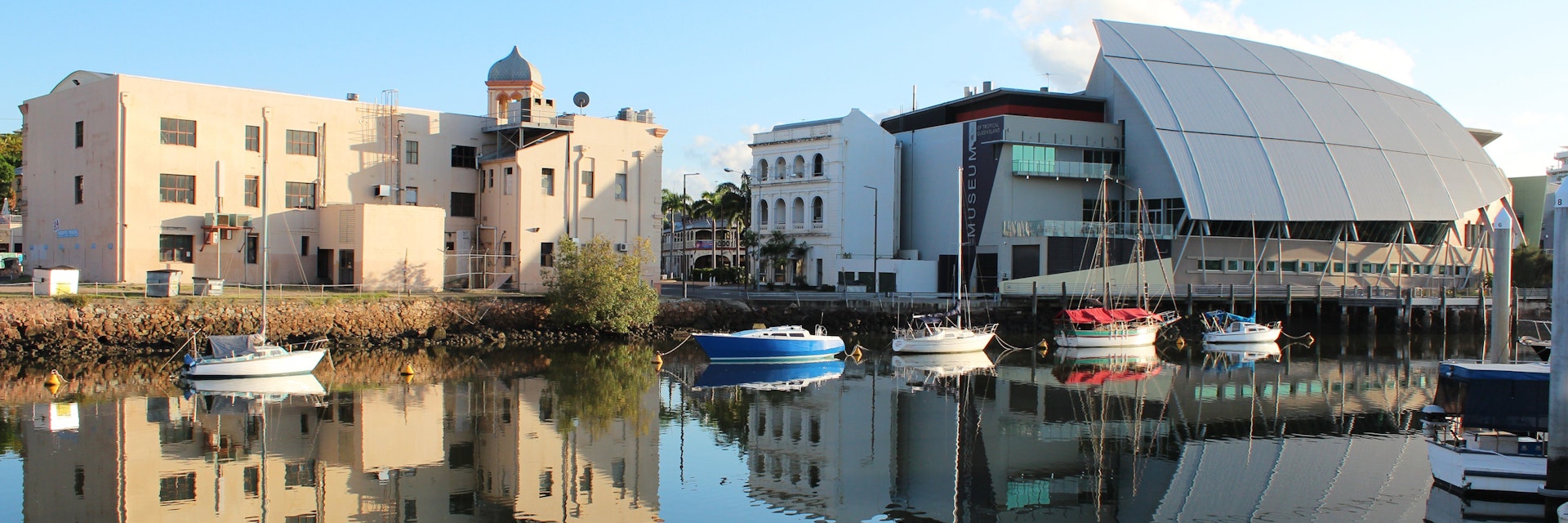 Bullwinkles Nightclub and Museum of Tropical Queensland (pictured at right) with reflection in water, Townsville. Australia
