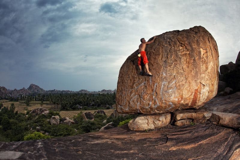A climber scales one of the thousands of boulders in Hampi