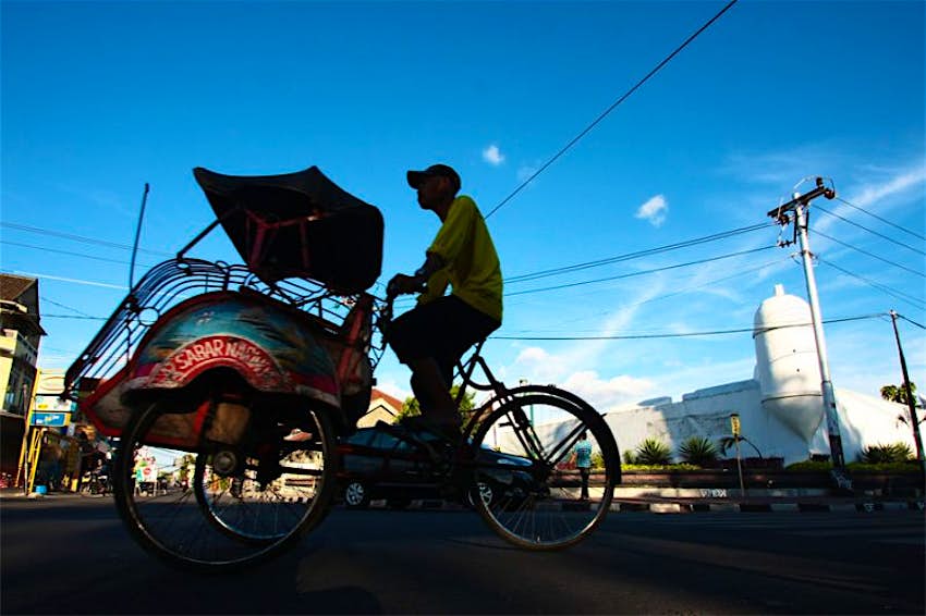 Sebuah becak tradisional melewati jalan-jalan di Indonesia