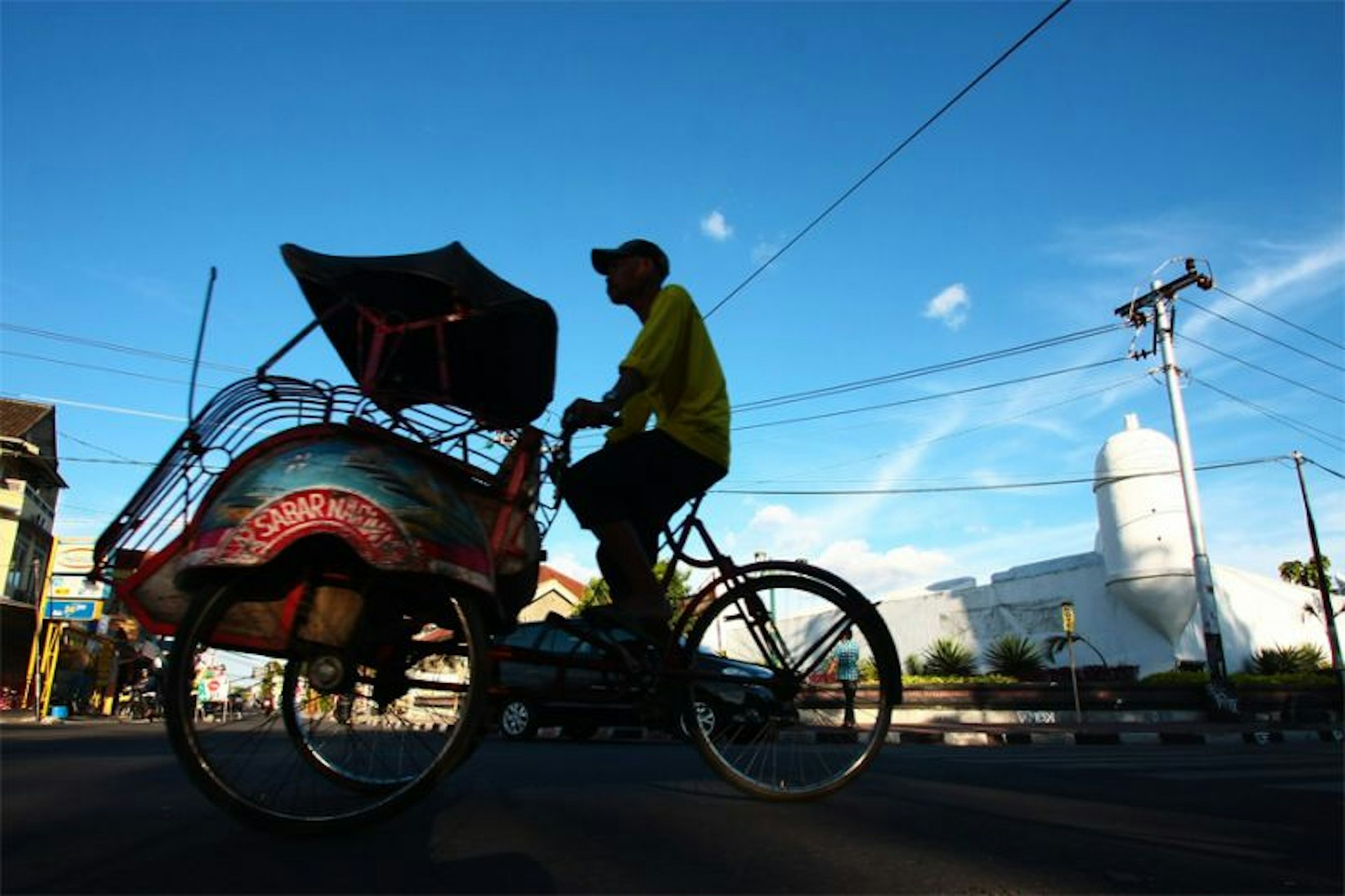 A traditional rickshaw rides through the streets of Indonesia