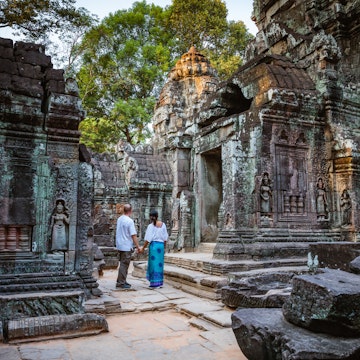 Adult couple of tourists visiting the temple ruins of Angkor, Siem Reap, Cambodia