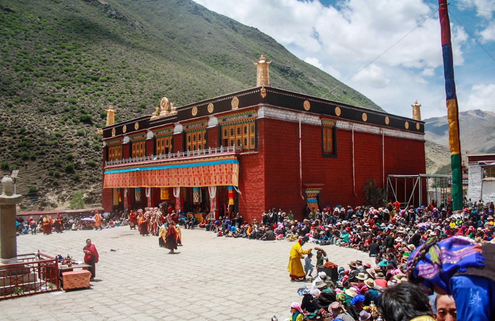 Tibet / China - Oct 2017: The Tibetan pilgrims on a celebrating the birthday of Buddha in red color famous Buddhist temple Tsurphu near Lhasa in Central Tibet. Sacred place for Buddha pupils.; 
Tsurphu Monastery

 Shutterstock ID 1097531960; your: Bridget Brown; gl: 65050; netsuite: Online Editorial; full: POI Image Update