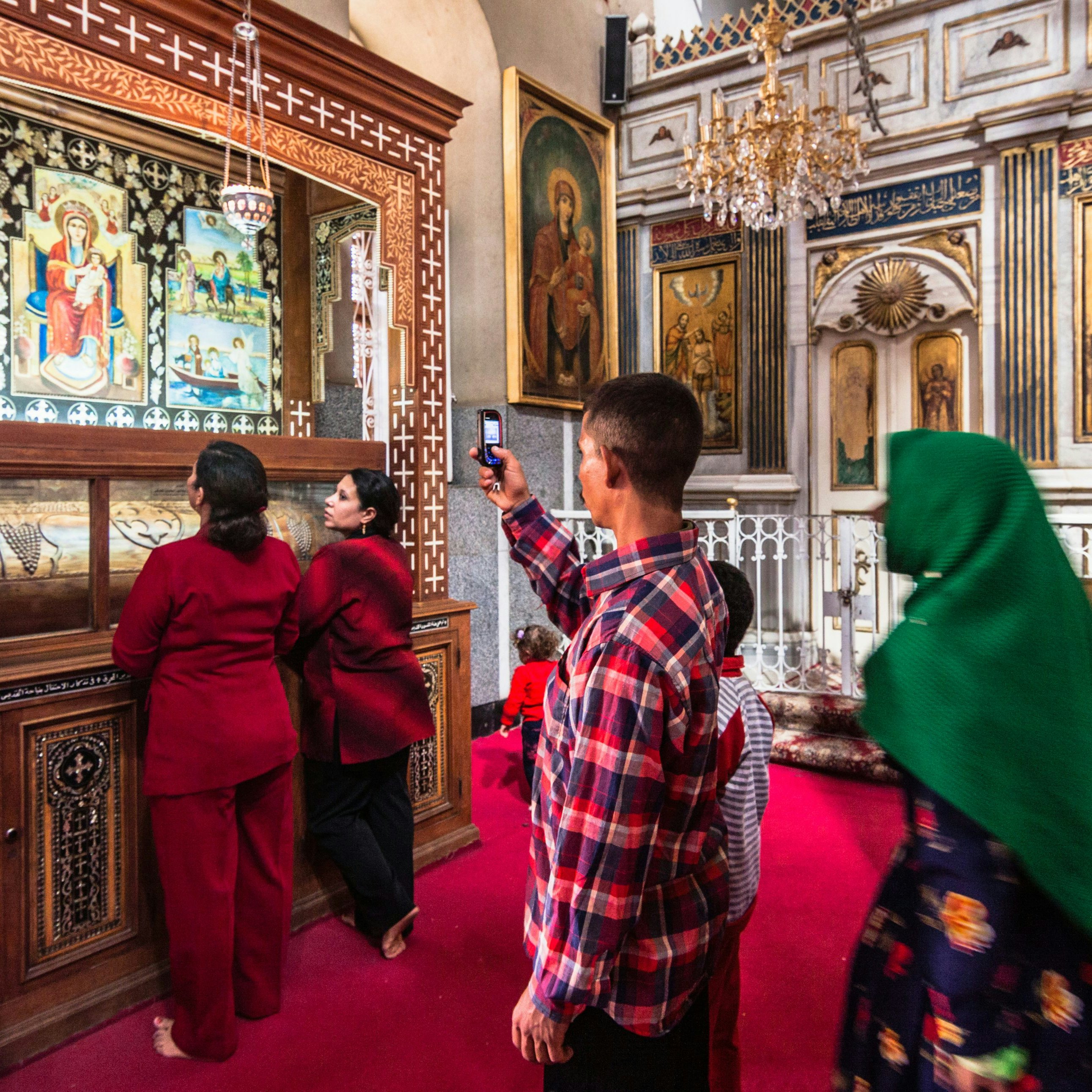 El-Qusiya, Egypt - November 4th, 2011: A Coptic family visits a shrine at Deir al-Muharraq monastery also called the Burned Monastery. Being one of the oldest functioning monasteries in the world it is an important pilgrimage place for Coptic Christians. Deir Al Muharraq monastery