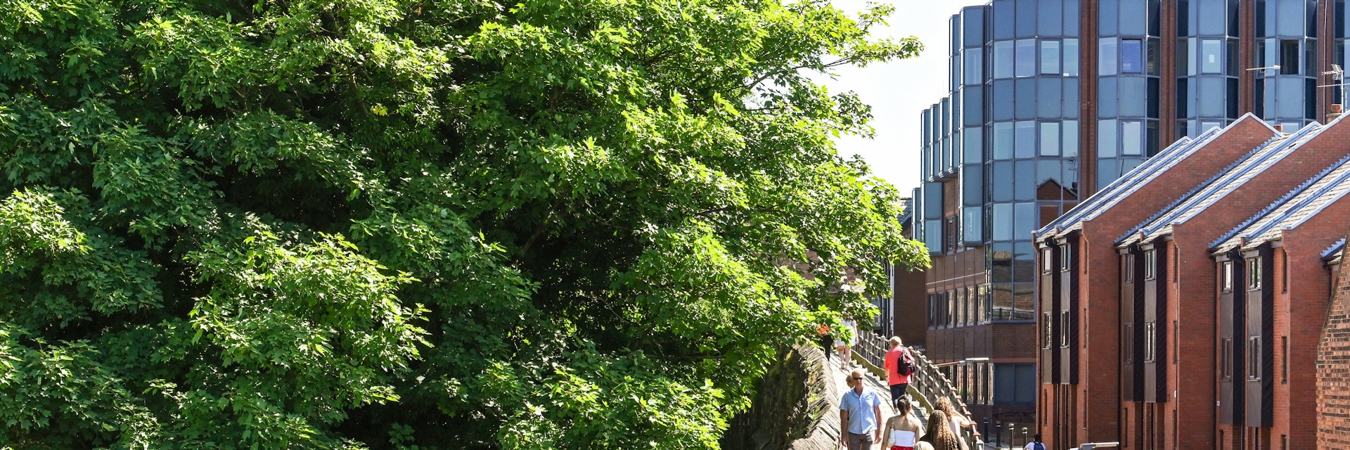 Chester, England - July 2021: Visitors walking on an elevated section of  the walk around the city's old wall.