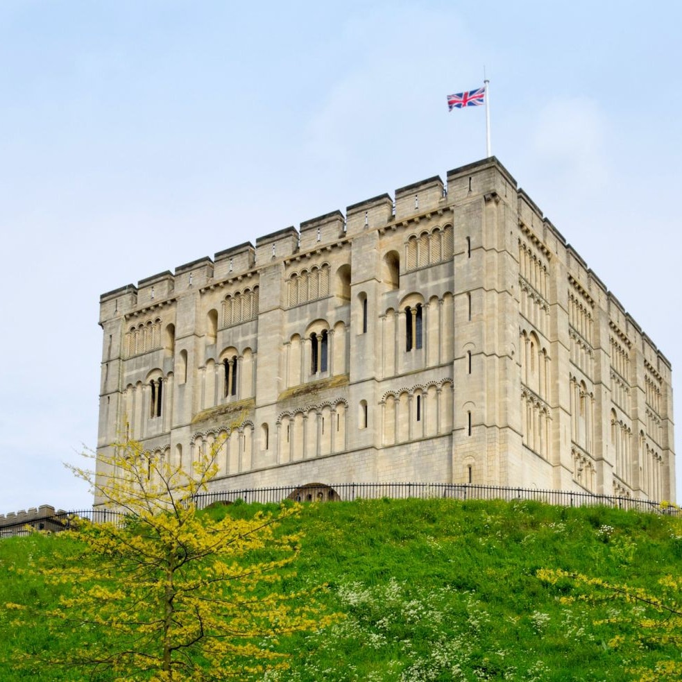 "Norwich, England - May 17, 2012: A man walking past Norwich Castle keep and castle mound on a spring day. The stone keep was constructed by order of the King between 1100 and 1120 to replace a wooden structure which stood on the same mound dating back to the Norman conquest of 1066. The castle was used as a prison until 1887 and has been used as a museum since 1894."