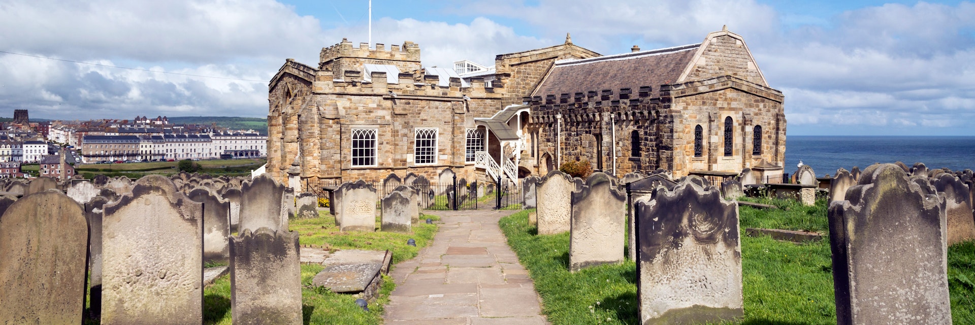 View of Whitby from St Mary's church, North Yorkshire, England - stock photo
Path in the graveyard beside this historic church on the cliff above the town of Whitby. A busy tourist destination with many attractions and a connection to the novel 'Dracula'.