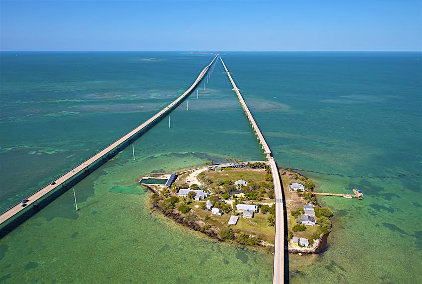An aerial view of Pigeon Key in turquoise waters, with the new and old Seven Mile Bridges on either side 
