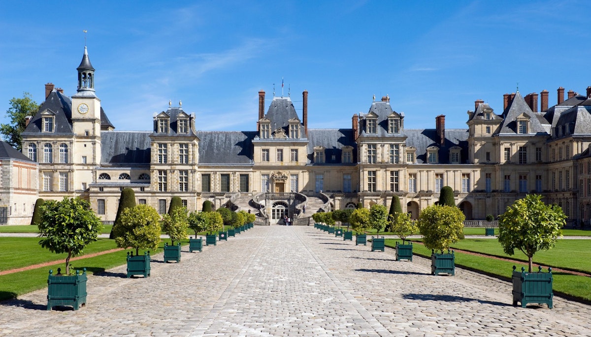 Planter Lined Cobble Stone Pathway Leading to Chateau Fontainebleau, France - stock photo
