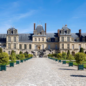 Planter Lined Cobble Stone Pathway Leading to Chateau Fontainebleau, France - stock photo