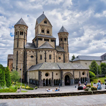 Maria Laach Abbey, the west end with the paradisium, a narthex enclosing a garden. Maria Laach Abbey (iAbtei Maria Laach) is a Benedictine abbey situated on the southwestern shore of the Laacher See (Lake Laach), near Andernach, in the Eifel region of the Rhineland-Palatinate in Germany in July 2020.