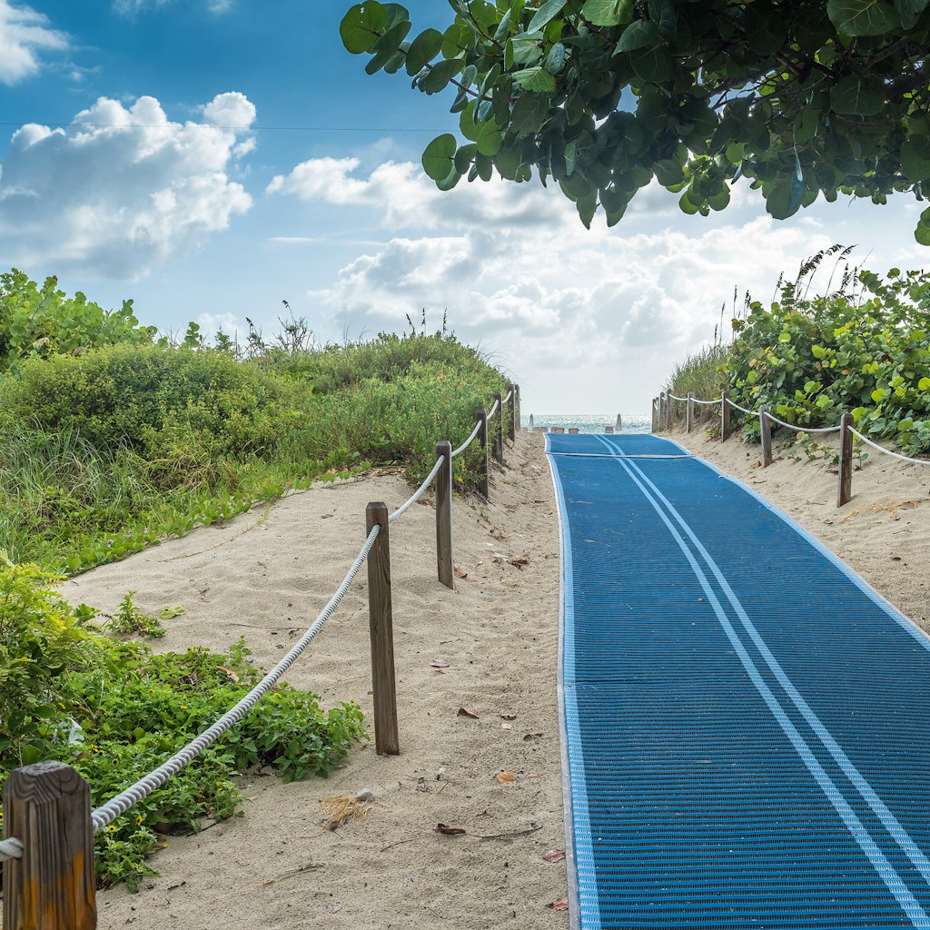 Blue pathway helping people with physical impairment going thru the beach sand.