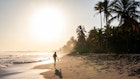 A woman walking at sunrise on the Caribbean Coast of Colombia