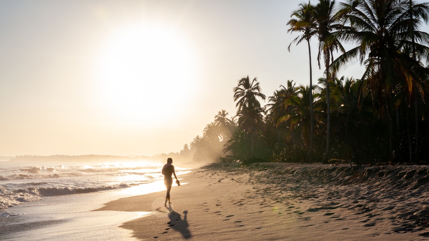 A woman walking at sunrise on the Caribbean Coast of Colombia