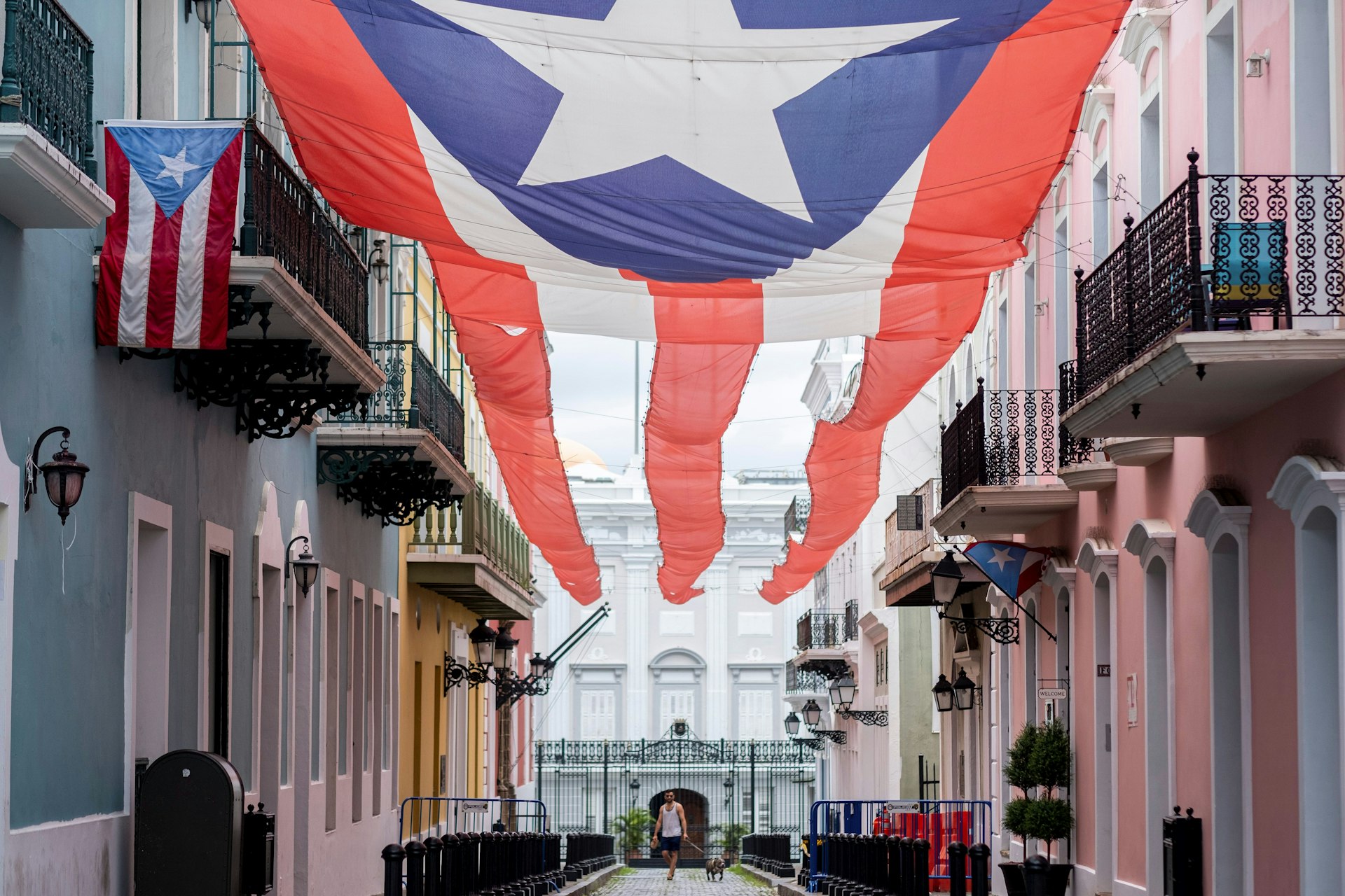 A man walks beneath the Puerto Rican flag in Old San Juan