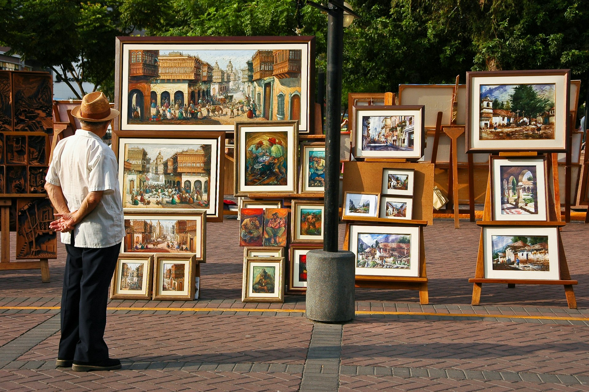 A man observes art on display in a public park, Lima, Peru