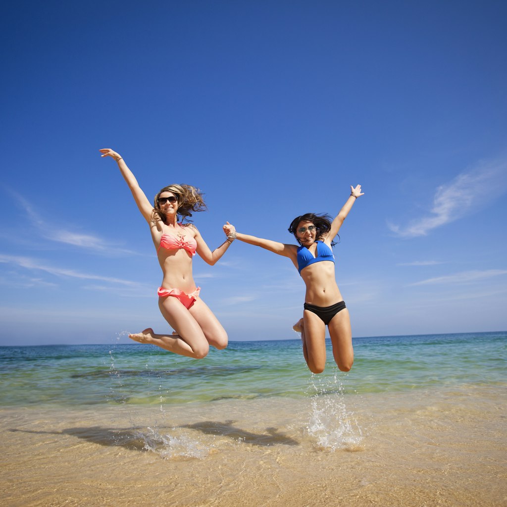 Two girls jumping into the sea at Puerto Vallarta