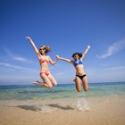 Two girls jumping into the sea at Puerto Vallarta