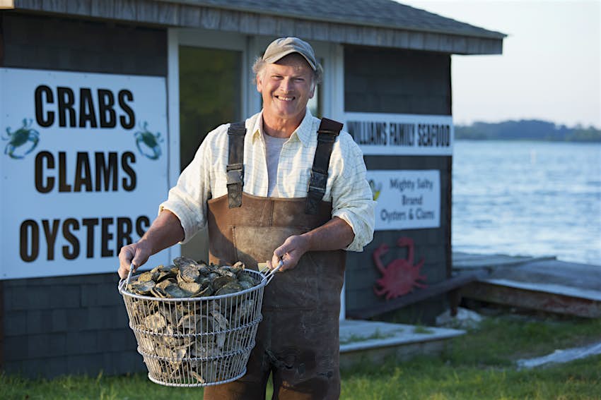An oyster fisherman holds a basket of oysters outside his seafood store in the Northern Neck peninsula of Virginia
