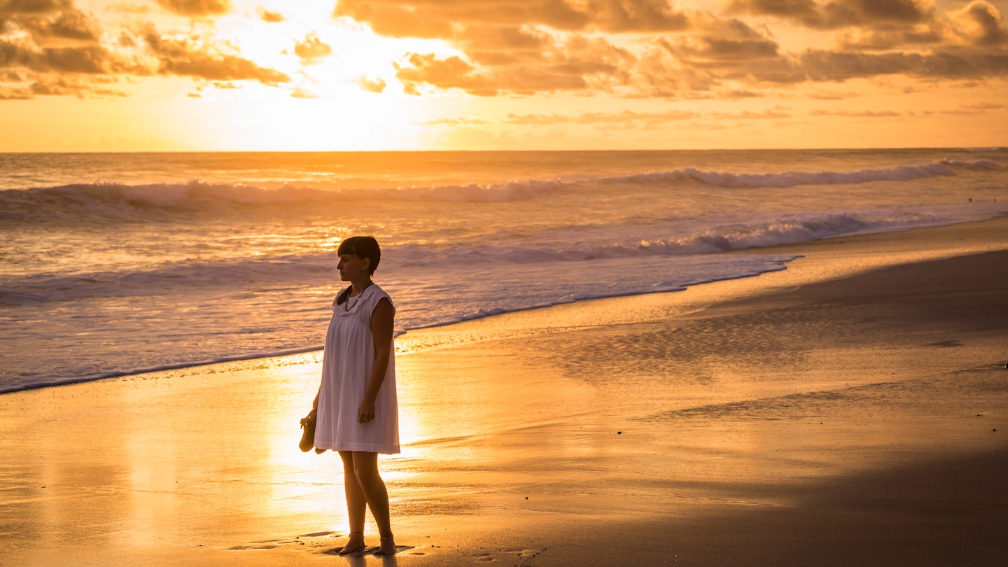 A female traveler admiring the sunset at Santa Theresa, Costa Rica